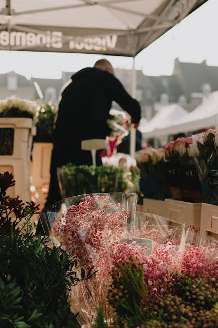 Fleurs en bouquets au premier plan sur un marché romain animé