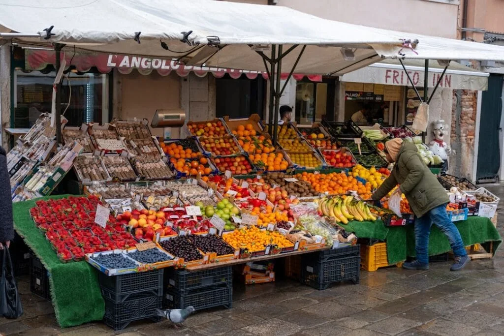 Étals de fruits colorés, client choisissant des bananes sur marché de Rome