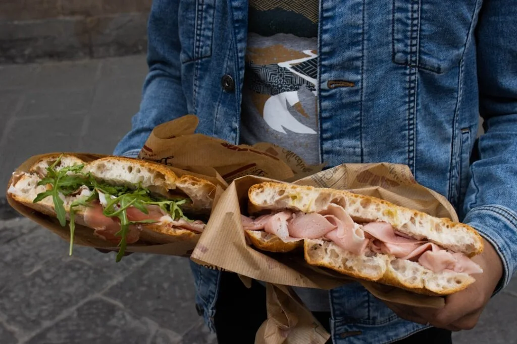 Deux focacce garnies de porchetta et roquette tenues à Rome