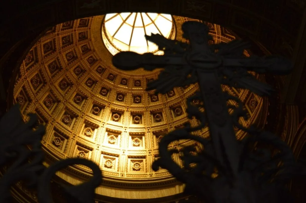Grille ouvragée en premier plan devant dôme doré à caissons, Vatican Rome