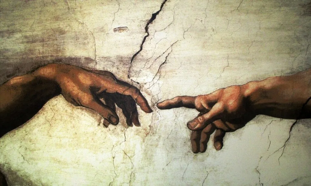 Gros plan sur les mains se touchant dans la Chapelle Sixtine