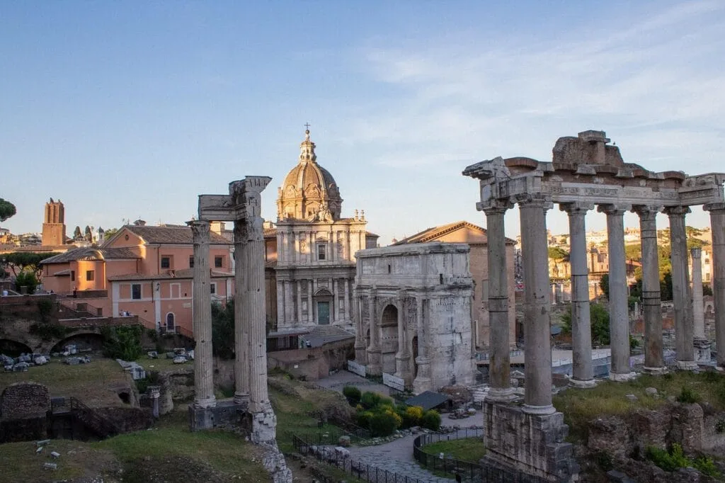 Vestiges du Forum Romain avec colonnes antiques et église en arrière-plan