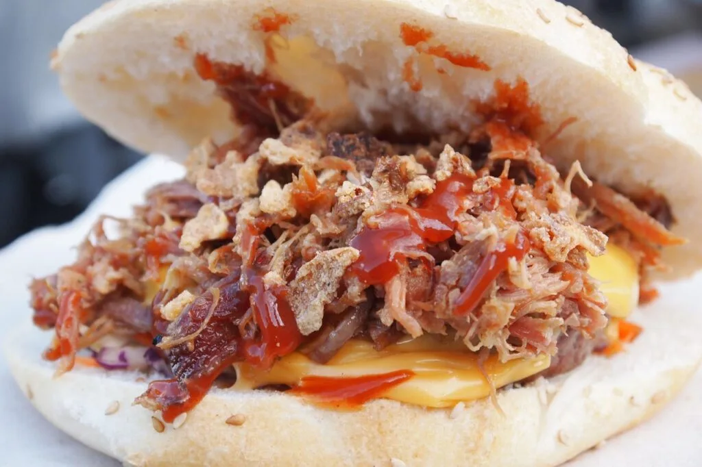 Panino romain garni de porchetta effilochée, fromage fondu et sauce