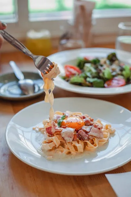 Fourchette enroulant pâtes crémeuses sur assiette, œuf et pancetta à Rome.
