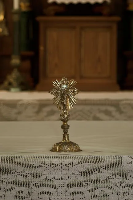 Petite croix dorée posée sur un autel en dentelle