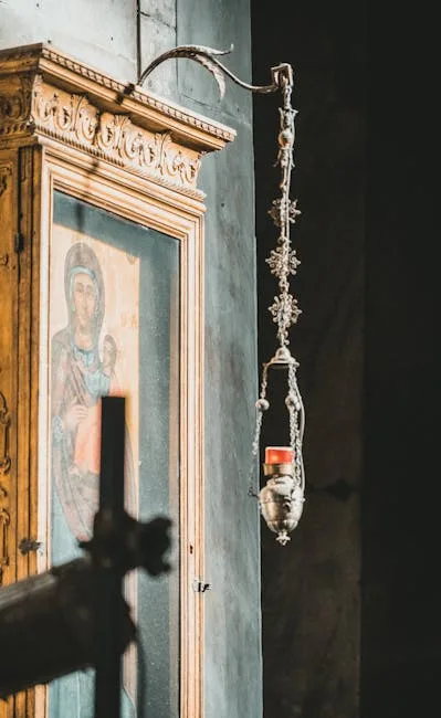 Lampe votive suspendue devant une icône de la Vierge dans une église