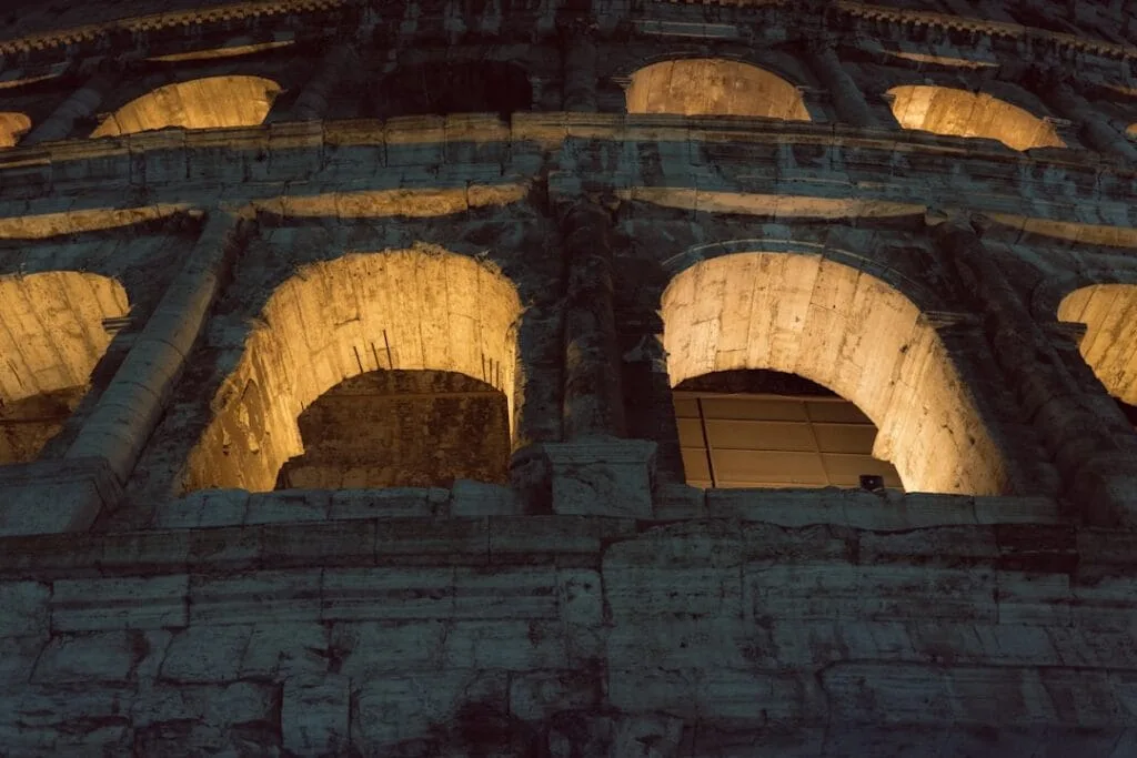 Arches éclairées du Colisée la nuit à Rome