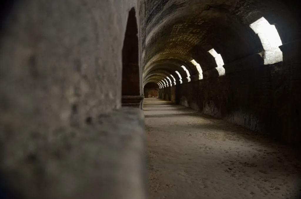 Couloir voûté des catacombes de Rome éclairé par petites ouvertures