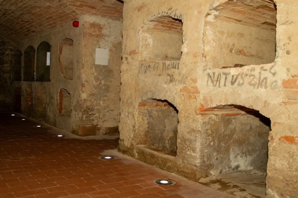 Niches funéraires creusées dans le mur des catacombes à Rome, sol carrelé