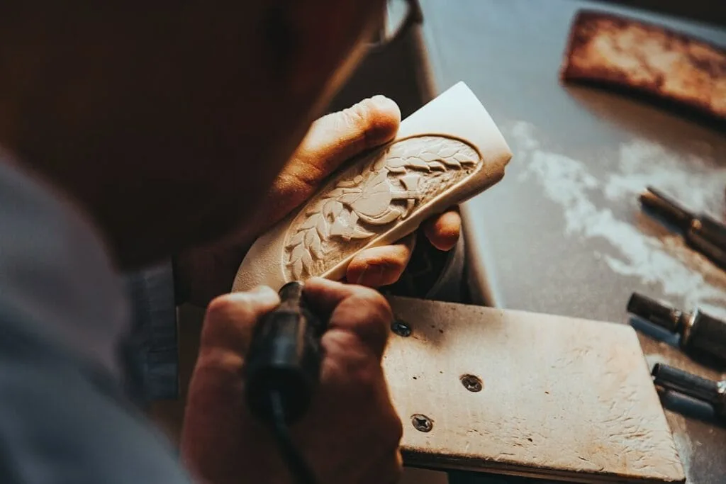 Artisan sculpte à la main une plaquette religieuse dans un atelier romain