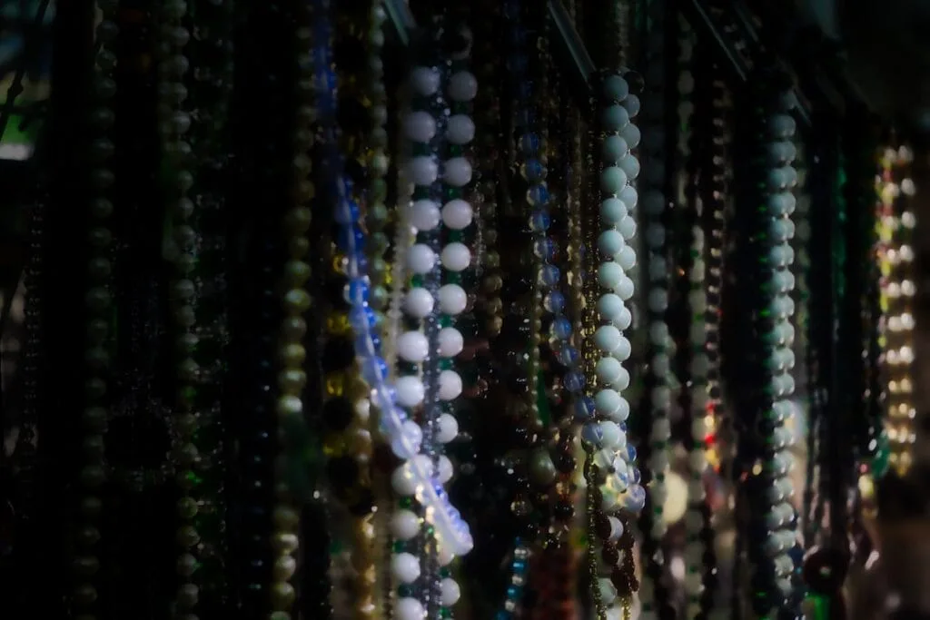 Chapelets et colliers de perles suspendus dans une boutique religieuse à Rome
