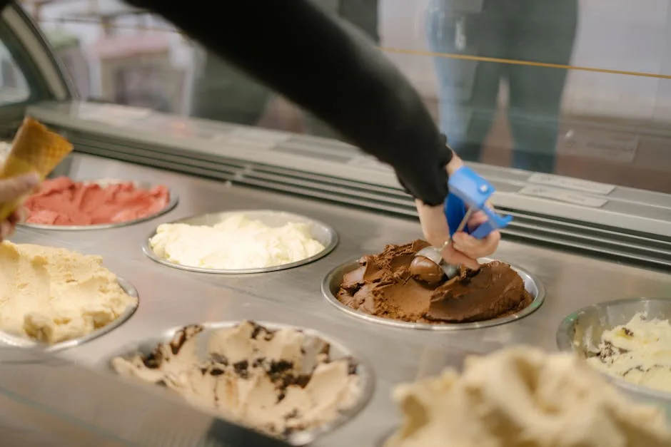 Main qui sert une boule de gelato au chocolat dans une gelateria romaine