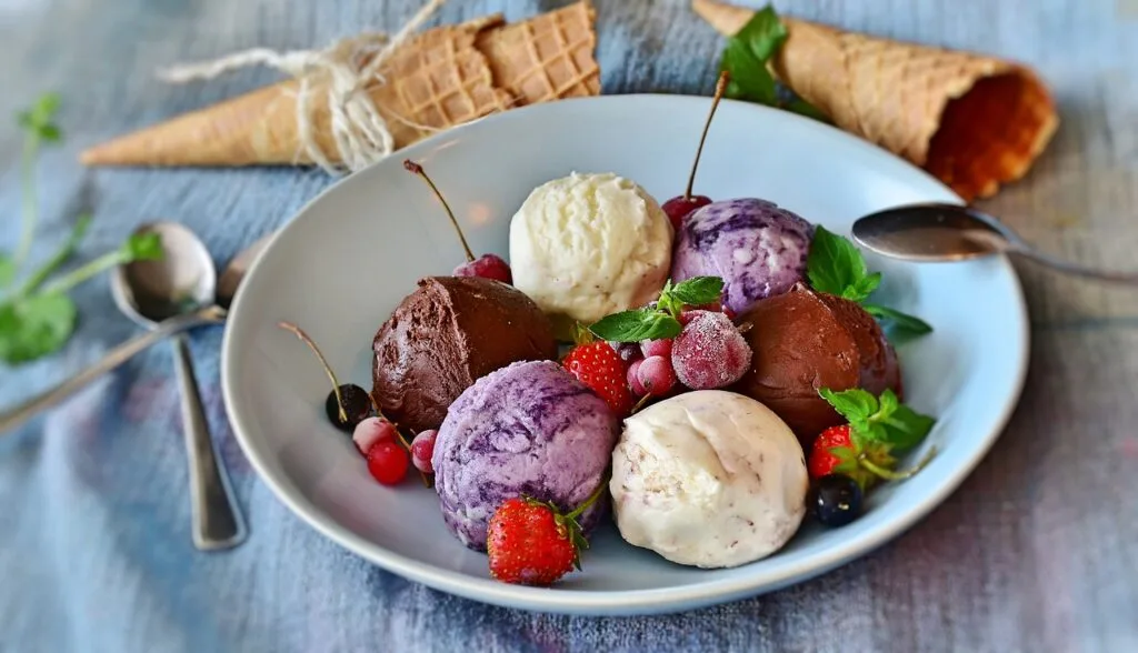 Assiette de boules de gelato variées garnies de fruits et menthe