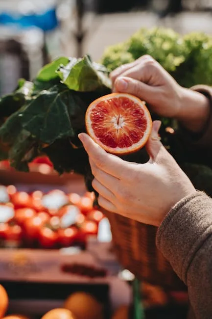 Mains tenant une orange sanguine fraîche au marché de rue