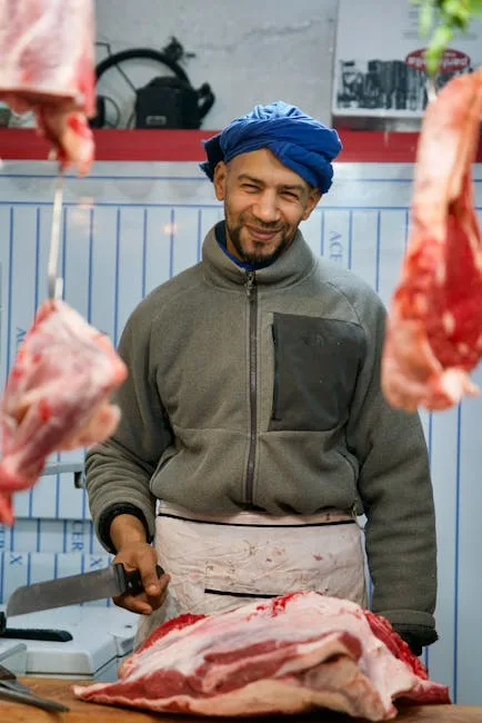 Boucher souriant préparant de grandes pièces de viande au marché